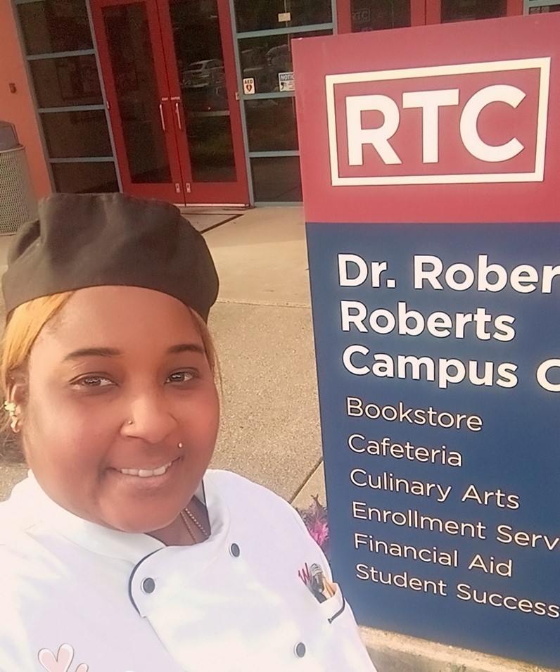 A selfie of Row in front of a sign for RTC.
