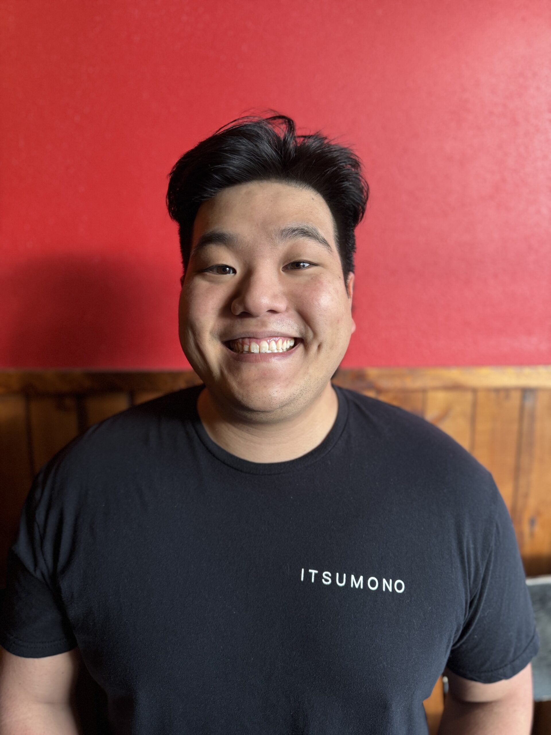 Chef Sean Arakaki looking and smiling at the camera wearing an Itsumono shirt
