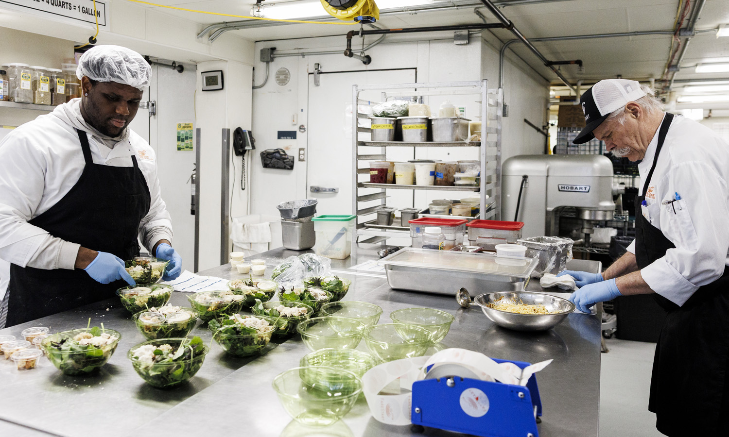 Two FareStart students preparing salads