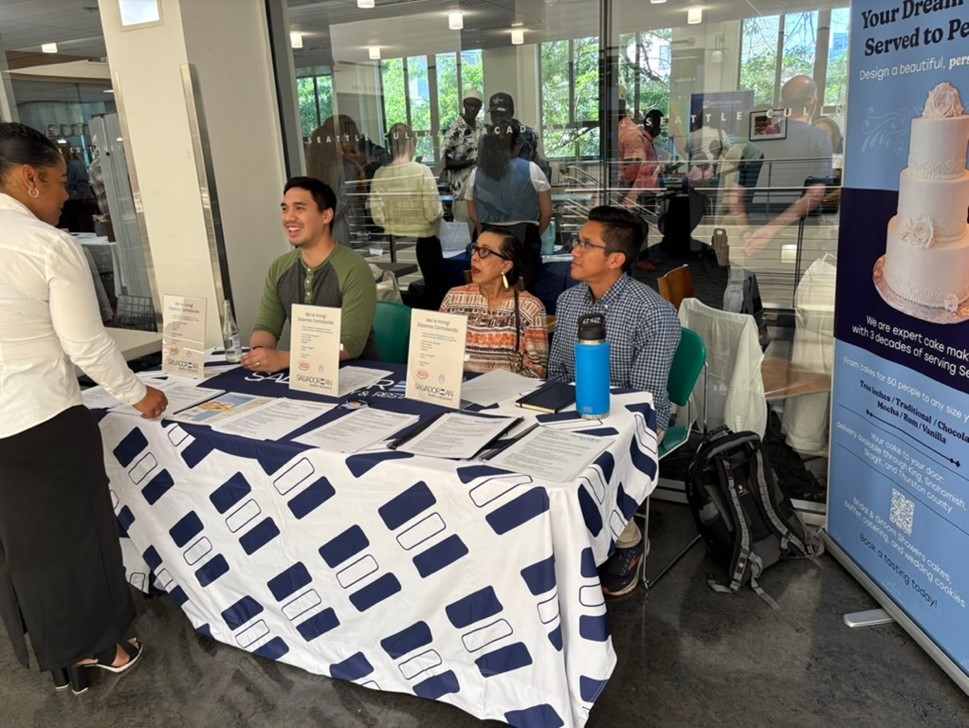 Three people talking to a job seeker at a job fair