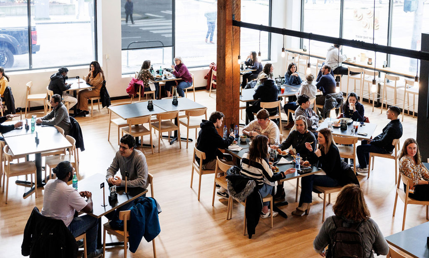 Customers sitting at tables eating and talking at the FareStart Restaurant