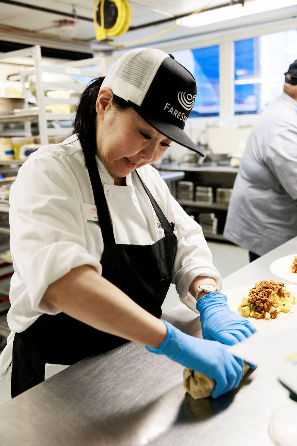 FareStart graduate rolling burritos in a commercial kitchen