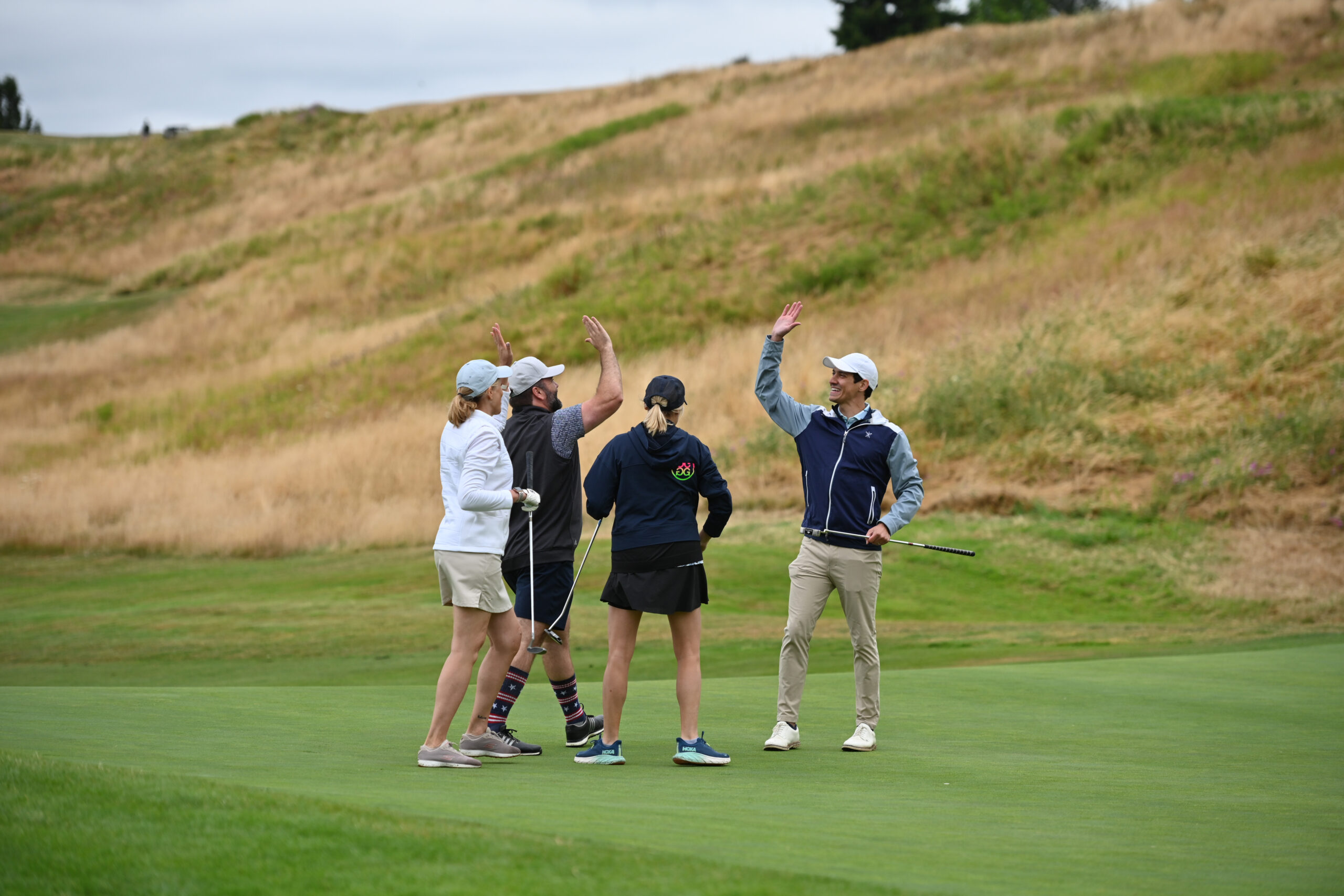 Amazon employees celebrating on the green during the Amazon Annual Golf Tournament benefiting FareStart