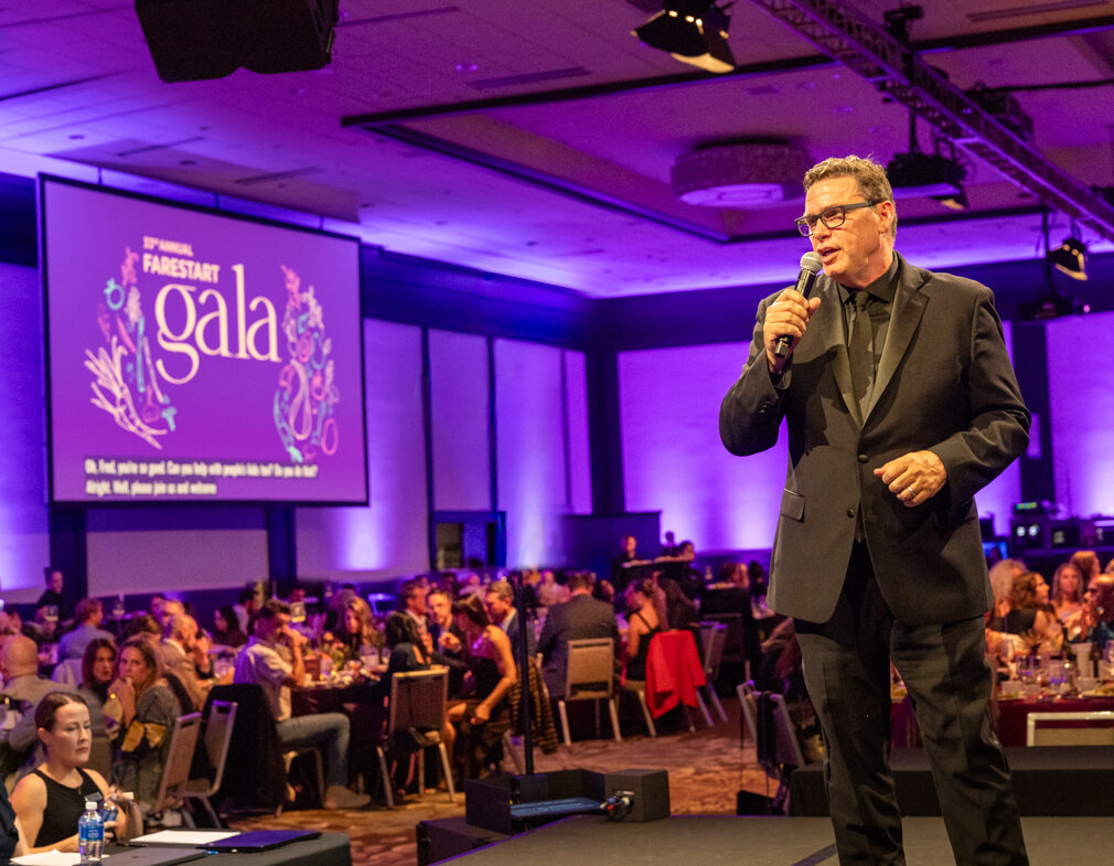 FareStart CEO Patrick D’Amelio onstage speaking into a microphone during FareStart