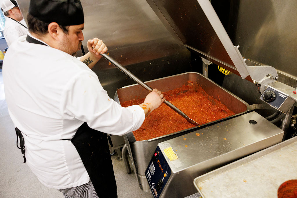 FareStart student in a commercial kitchen setting using a tilt skillet