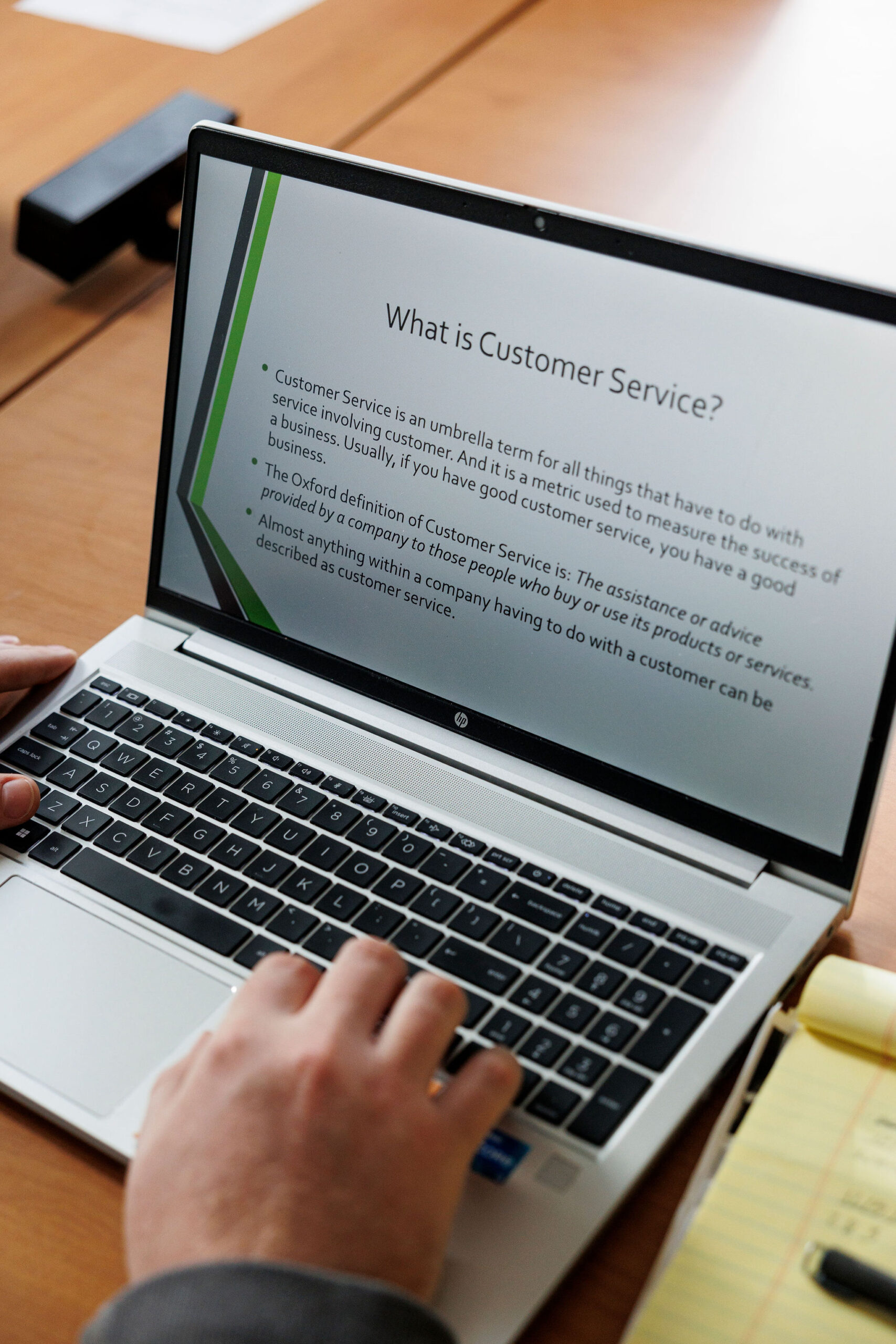 Computer screen displaying "What is Customer Service?" presentation slide