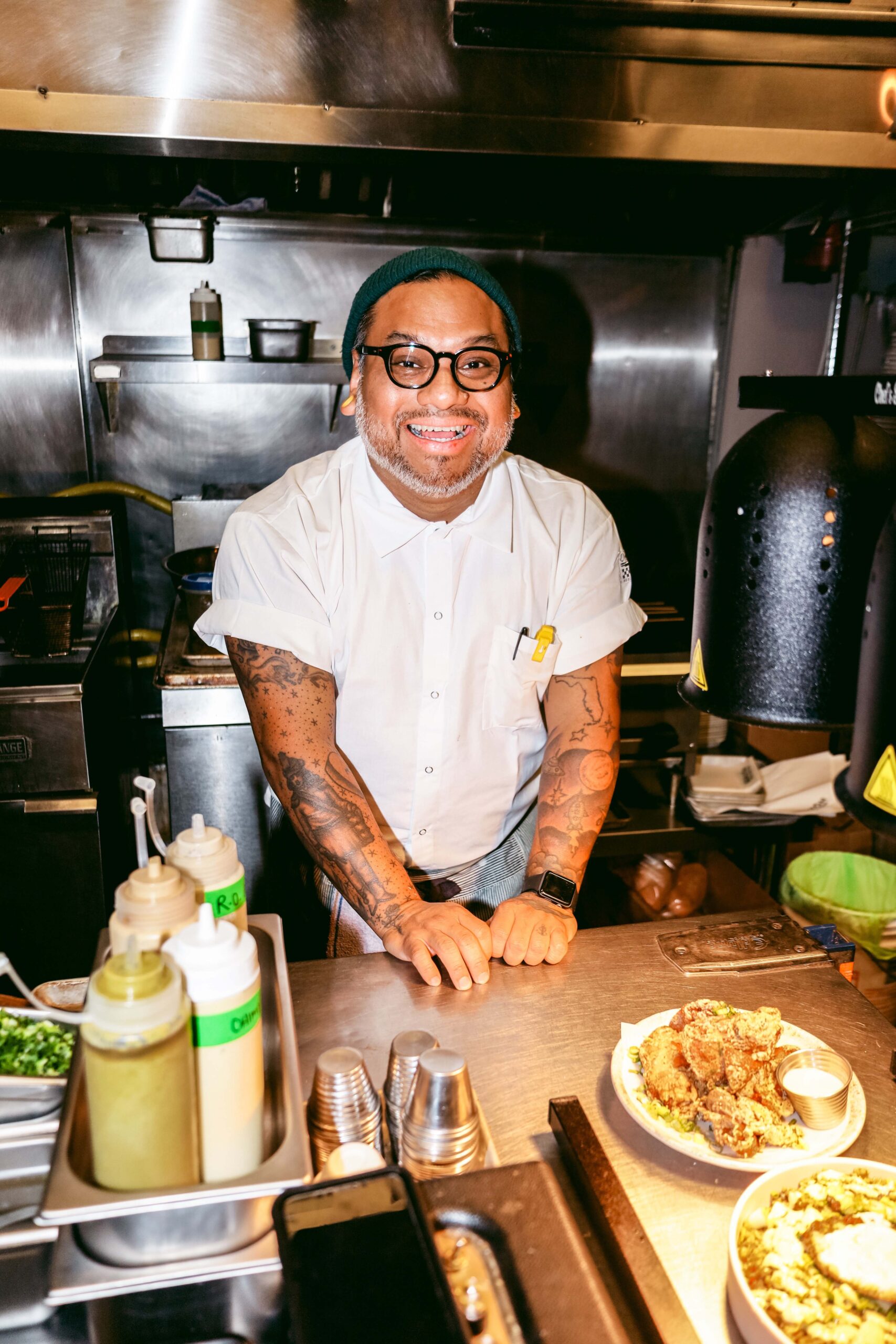 José Garzón standing in a kitchen next to plated food