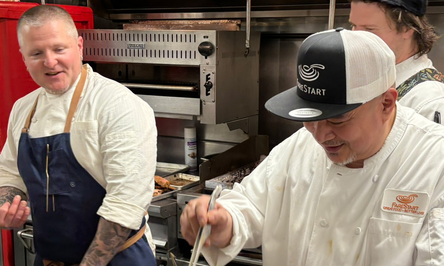 Chef Brendan McGill (he/him) of Hitchcock Restaurant Group shares a laugh in the kitchen at FareStart Restaurant during our April 2 Guest Chef Night
