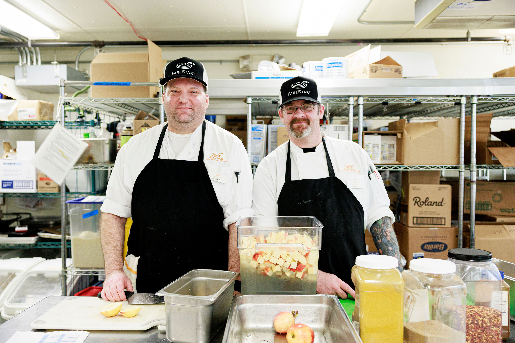 Two Food Pathways Program Students standing next to each other chopping apples in the kitchen