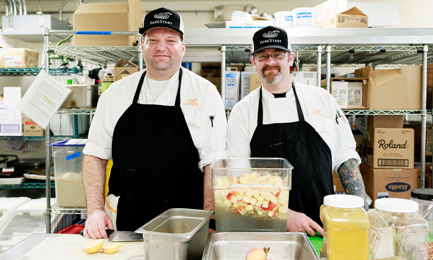 Two Food Pathways Program Students standing next to each other chopping apples in the kitchen