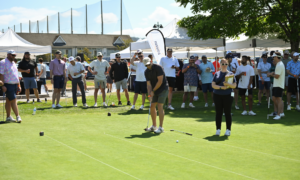 a group of Amazon Golfers watching a golfer make a put at the Amazon Golf Tournament